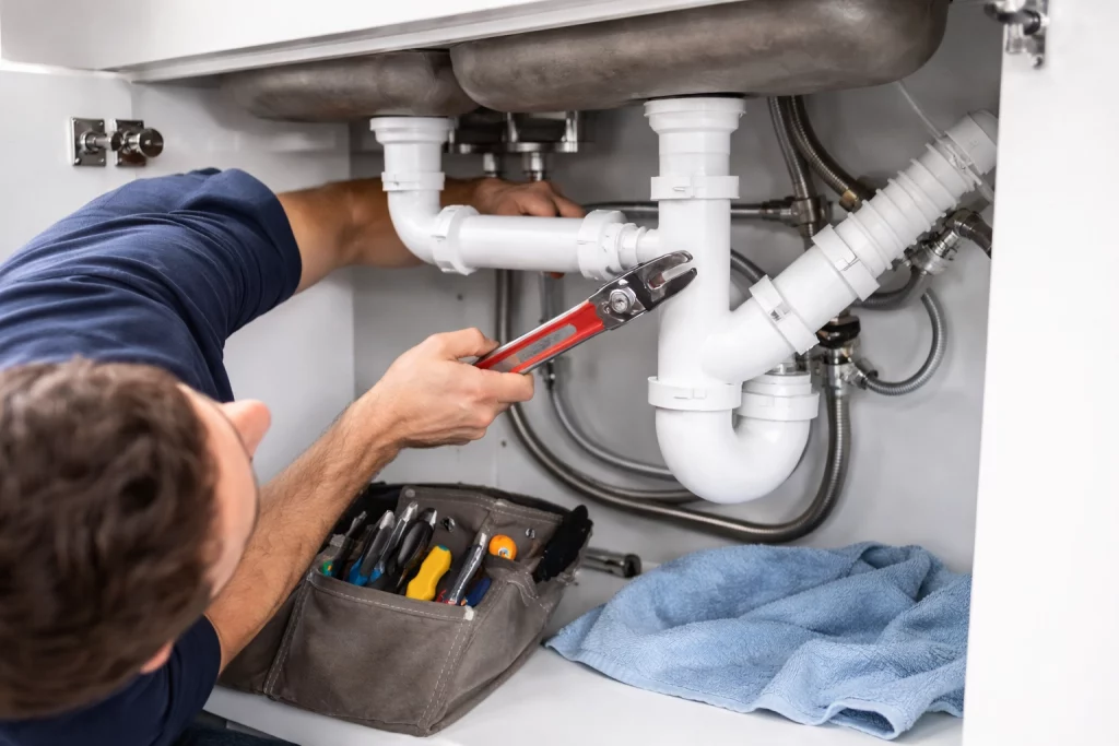 Plumber carrying out plumbing repairs in Manchester property